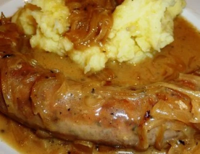 Saucisse confite de porc sauce aux oignons et purée 