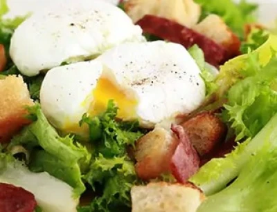 Salade de chicorées, oeuf mollet, croûtons et lardons de ventrêche