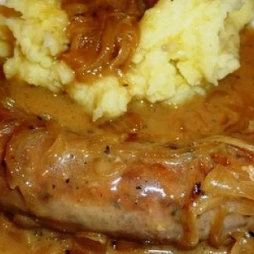 Saucisse confite de porc sauce aux oignons et purée 