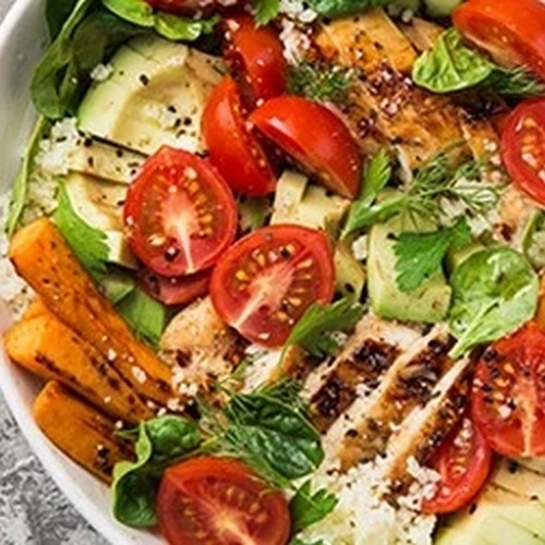 Bowl de pousses d'épinard, patate douce, avocat, tomate et poulet